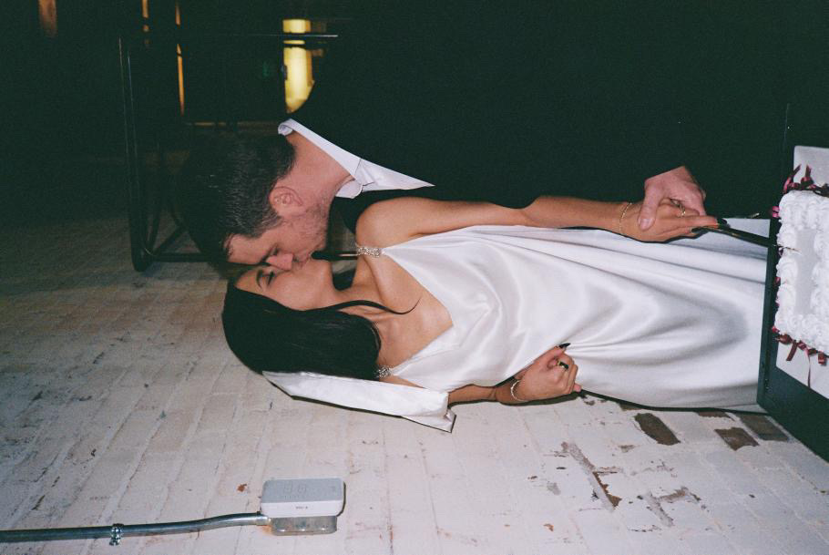 film photography of bride and groom cutting cake